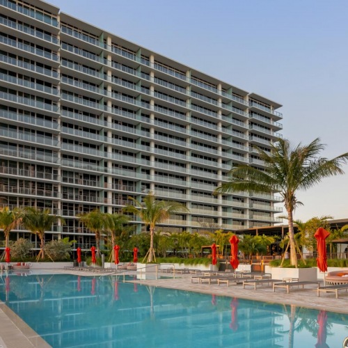 Shimmering resort-style pool a large building with a pool in front of it