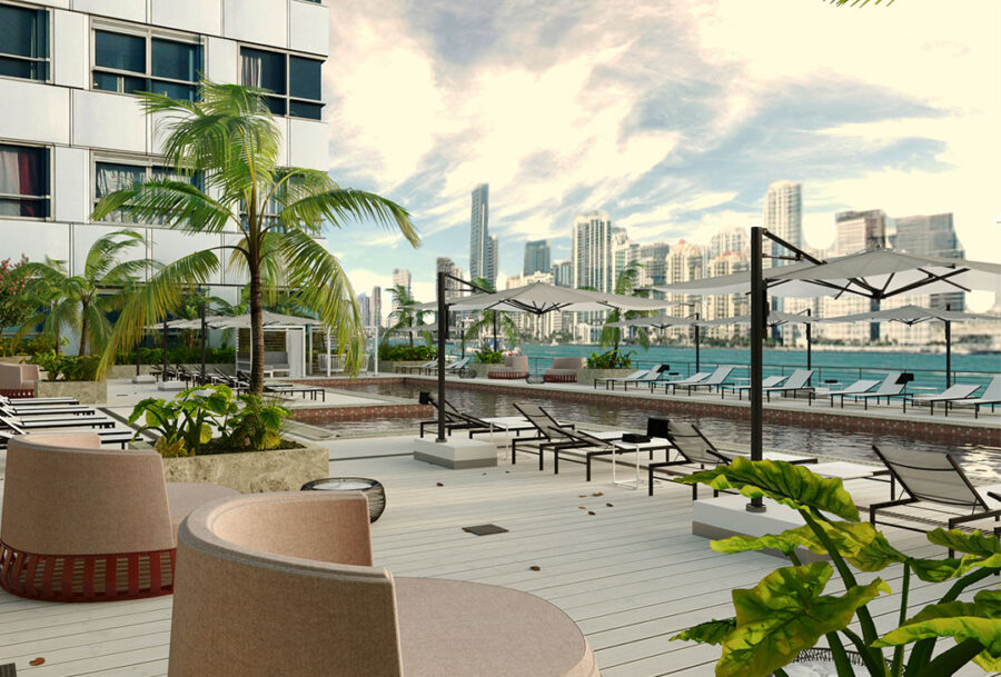 Outside deck with a variety of lounge seating, umbrellas, tropical landscaping and resort-style pool