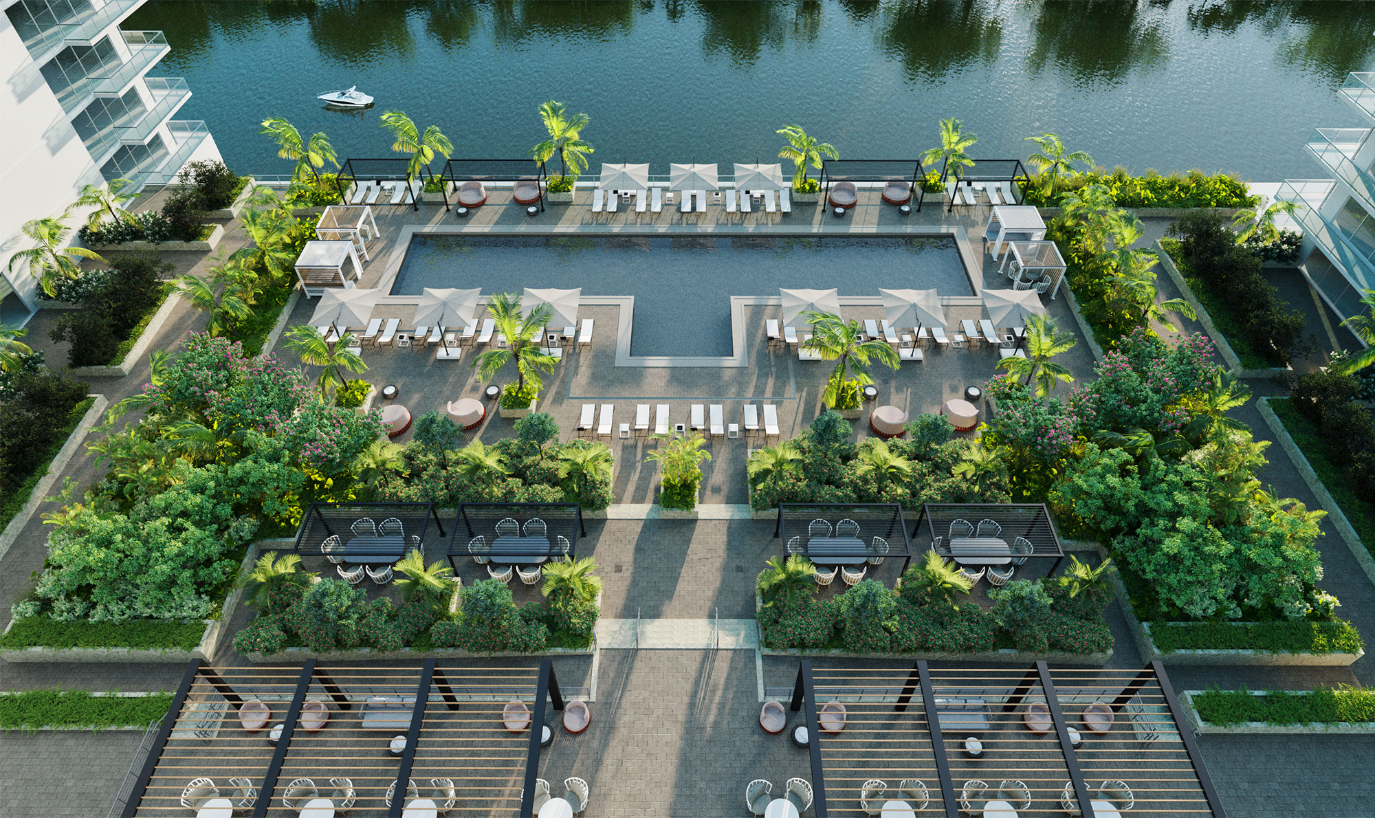 Aerial view of resort-style pool by the River Walk with lush landscaping, lounge seating, umbrellas, and covered seating